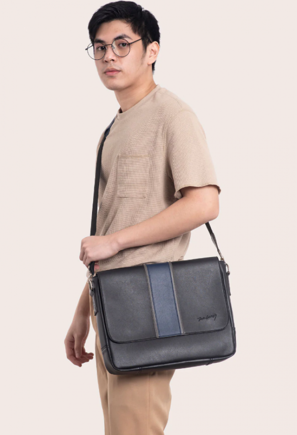 Tas messenger dengan aksen tali kulit dan detail magnetik